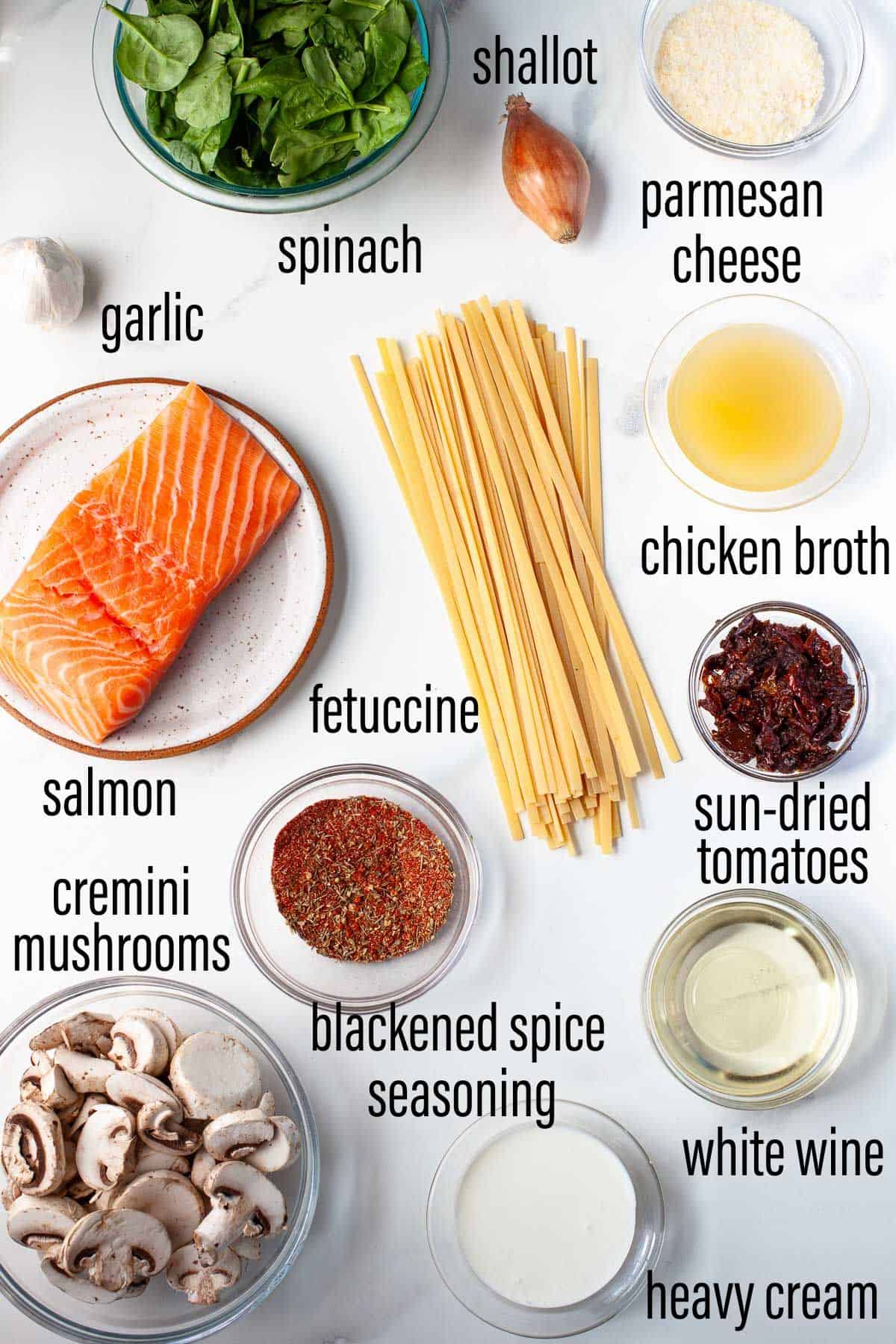 graphic of ingredients for blackened salmon pasta on marble surface with black text overlay.